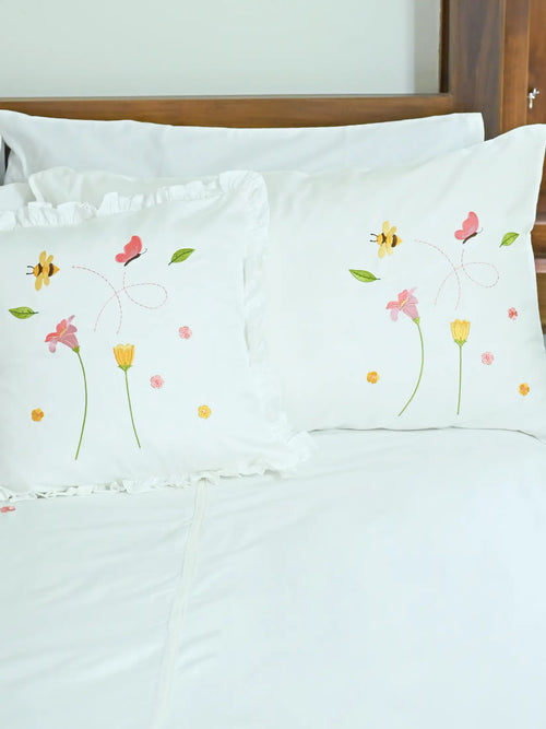 Two white Bees and Blossom embroidered pillowcases, one plain edged and one ruffled