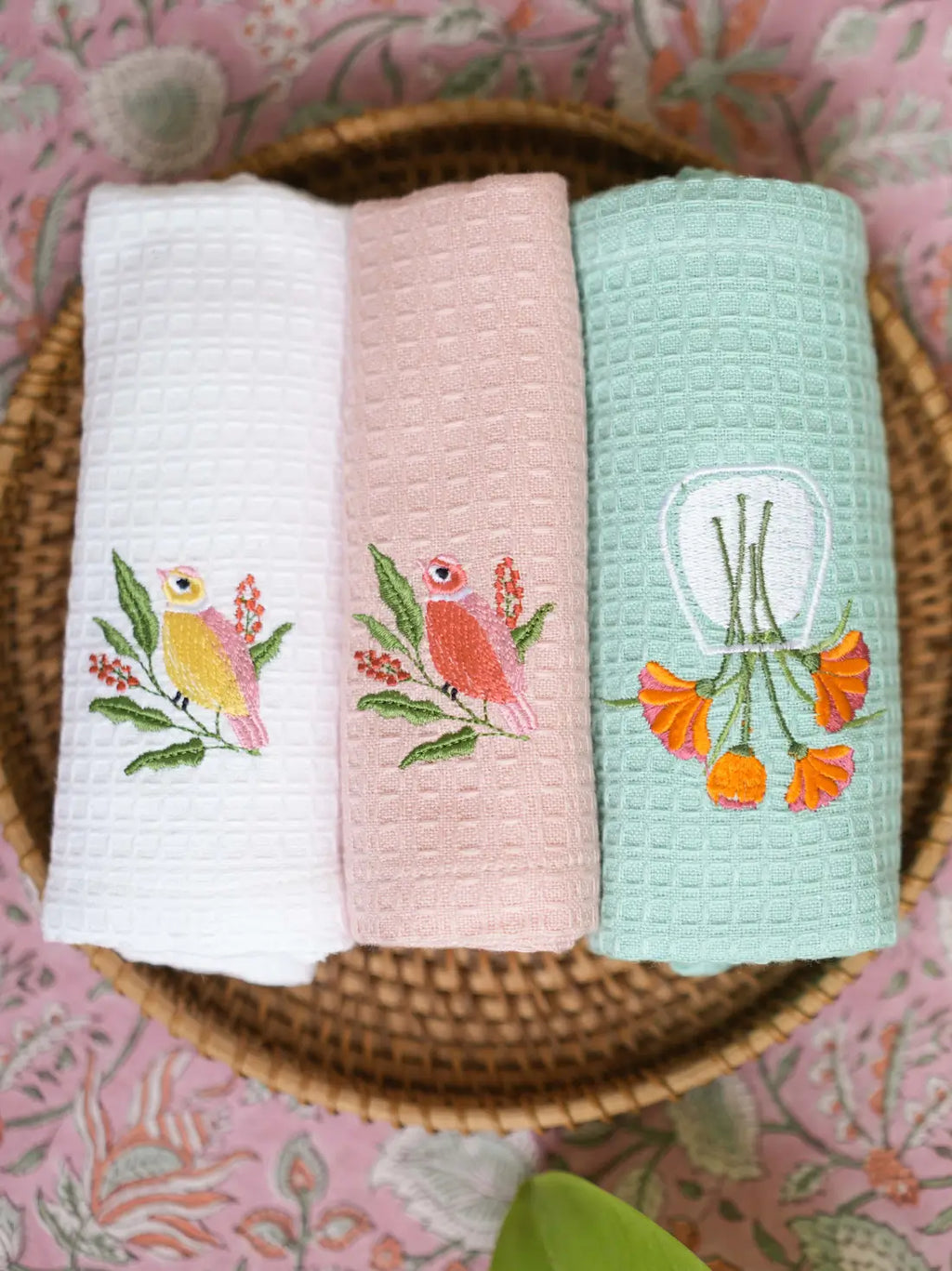 Three embroidered waffle hand towels in white, blush pink and mint green