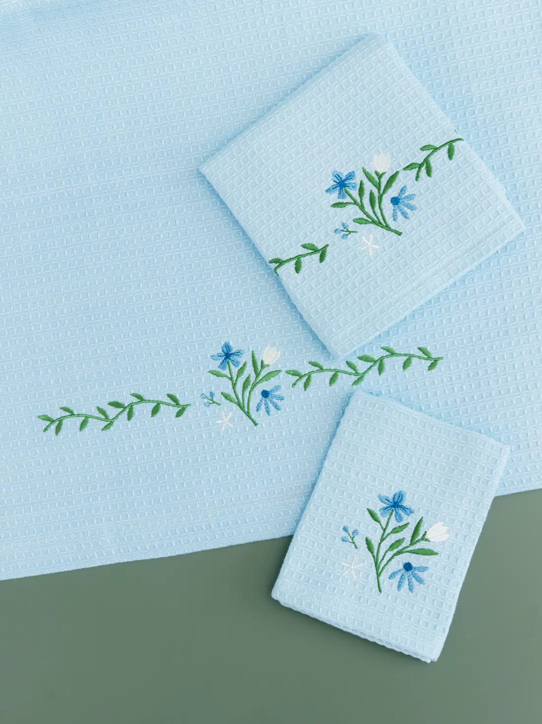 Pale blue waffle bath, hand and face towels with blue and white floral embroidery