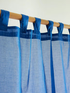 Close-up of fabric hanging loops on a blue sheer curtain