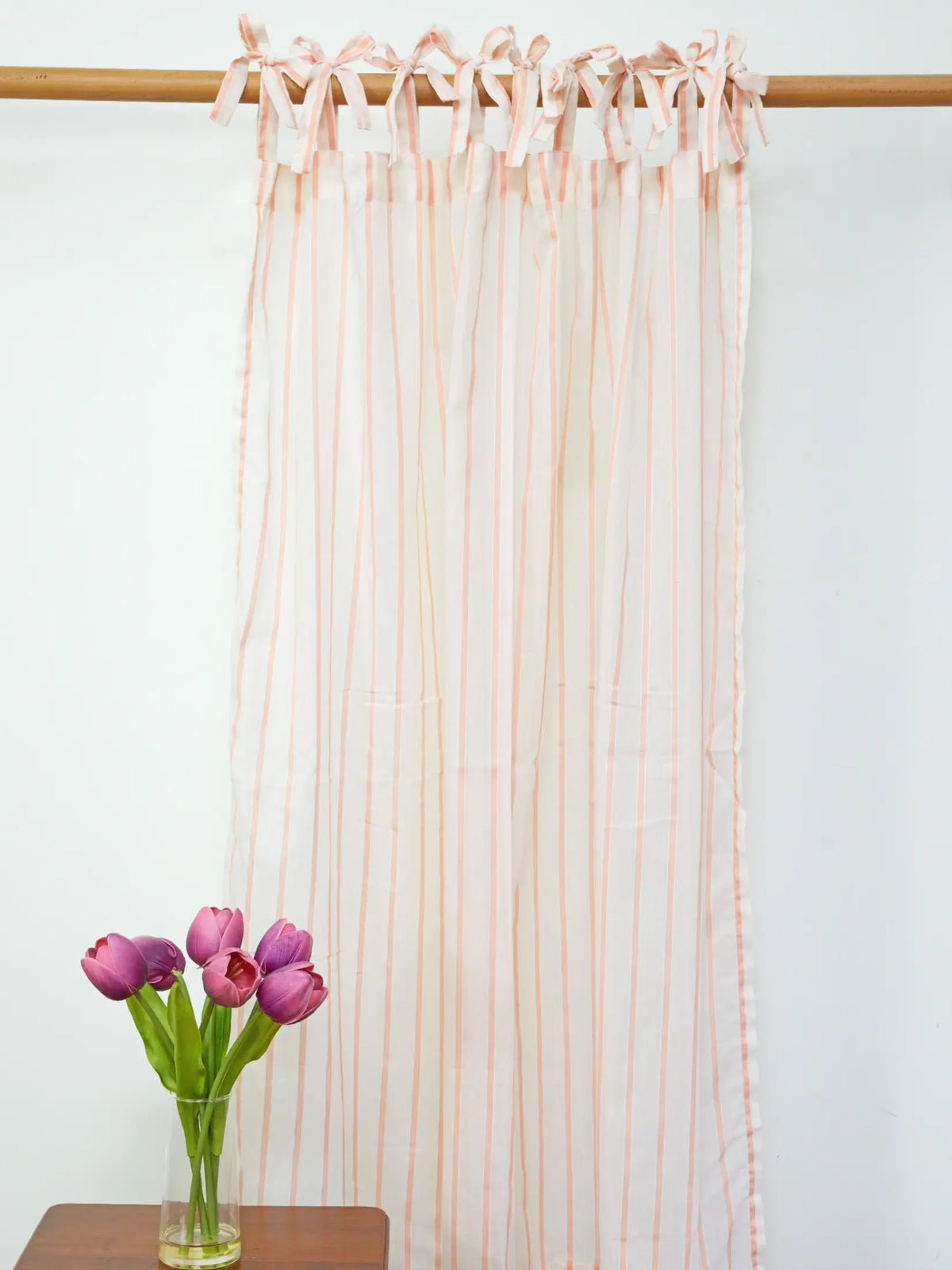 Full-length white sheer curtain with peach stripes and tie-top bows