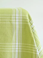 Close-up of light green woven tablecloth fabric with white plaid stripes