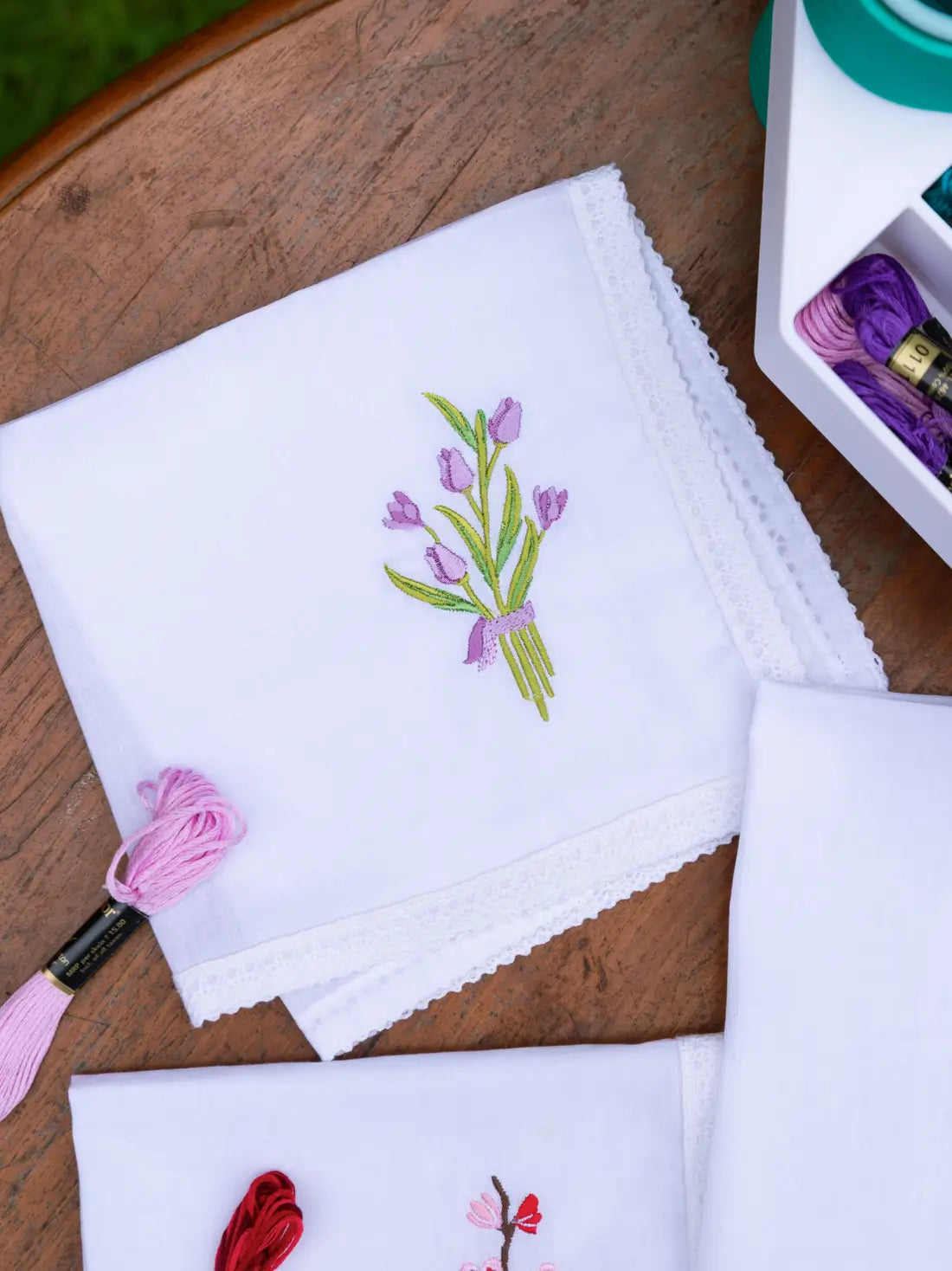 White lace-edged handkerchief with a purple tulip bouquet embroidered in one corner