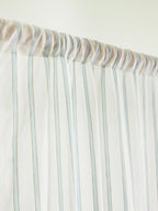 Close-up of the gathered rod pocket and powder blue stripes on a white sheer curtain