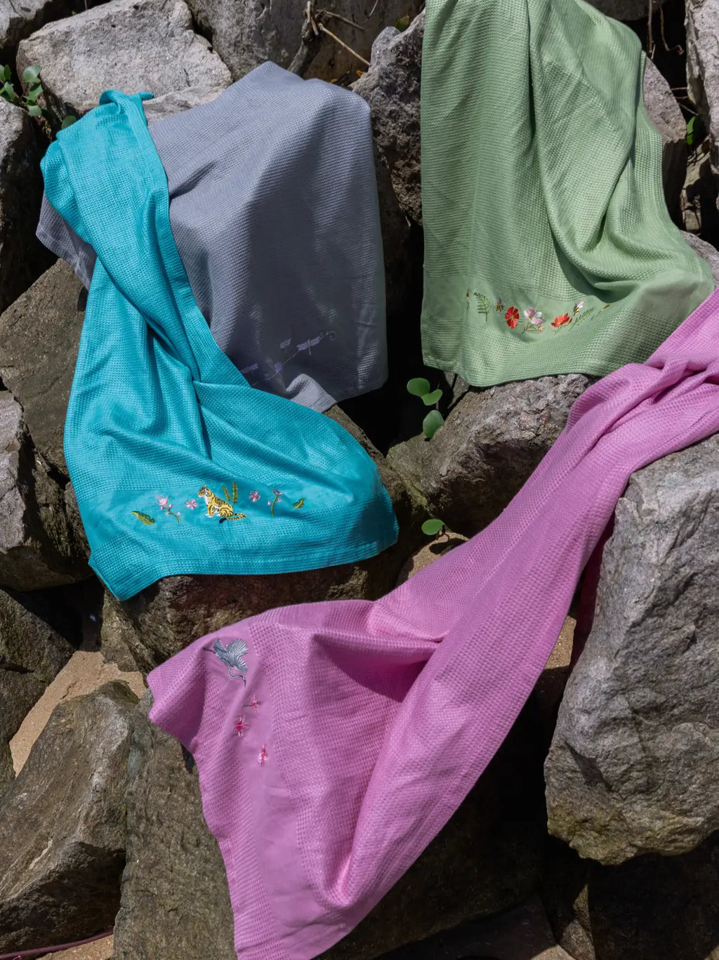 Teal, grey, sage green and pink waffle towels with assorted animal and floral embroidery
