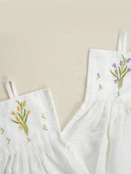 Close-up of yellow and purple tulip bouquets embroidered on two white hanging hand towels