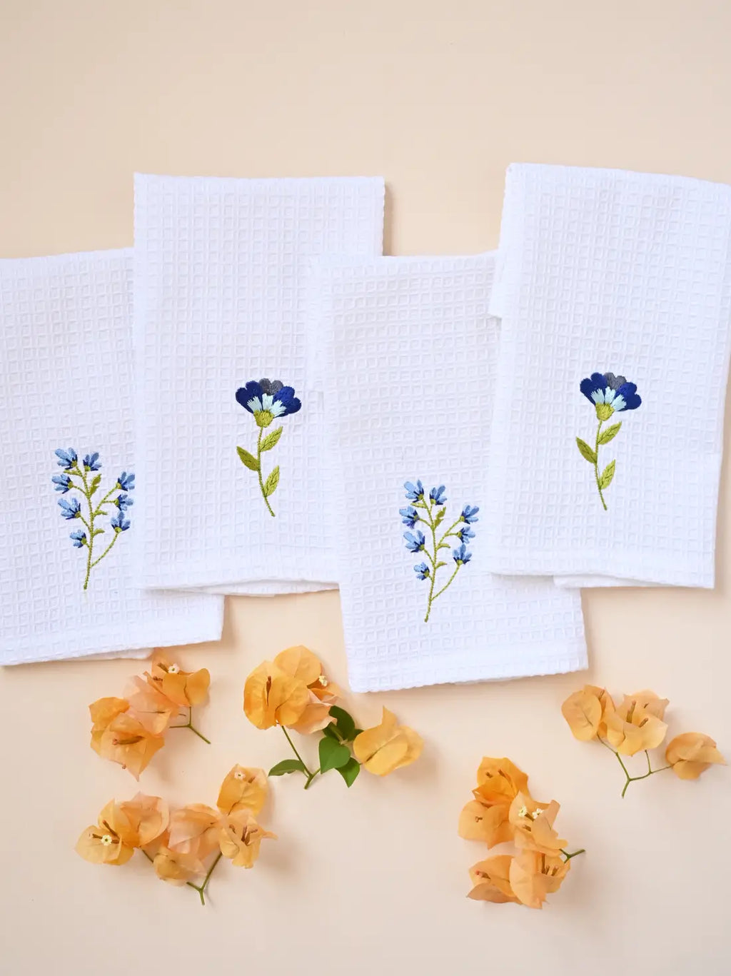 White embroidered waffle face towel set of four with blue botanical motifs