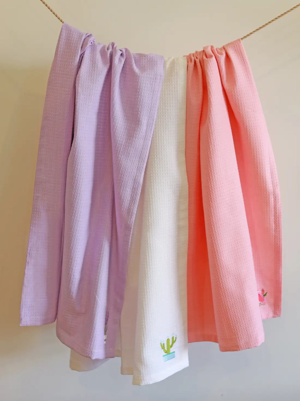 Lavender, white and coral waffle bath towels hanging on a line